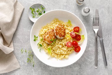 Tavuk köfteli kuskus, pirzola ve domates, tepeden aşağı görüş.