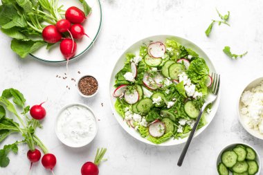 Turp ve salatalık taze yeşil yapraklı sebze salatası romaine marulu, süzme peynir ve yoğurt.