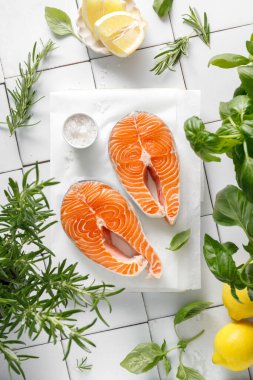 Taze somon bifteği, otlar ve yemek malzemeleri, üst manzara.