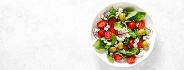 Taze sağlıklı sebze salatası, beyaz peynir, domates, zeytin, yeşil biber ve yeşil fesleğen yaprağı, afiş, üst manzara.