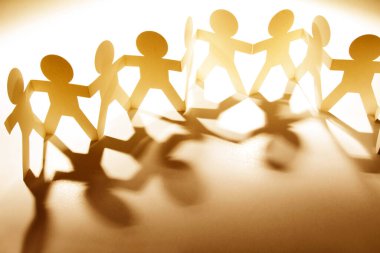 Kağıt zincire bağlı insanlar el ele tutuşuyorlar.