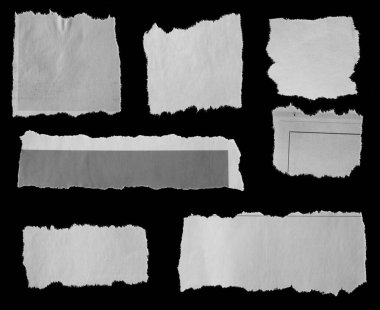 Siyah arka planda yedi parça yırtık gazete