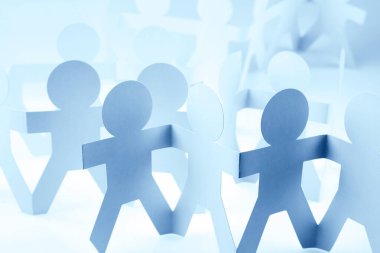 Kağıt zincire bağlı insanlar el ele tutuşuyorlar.