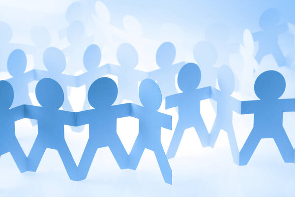 Команда людей из бумажной цепи объединилась, взявшись за руки