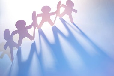 Kağıt zincire bağlı insanlar el ele tutuşuyorlar.