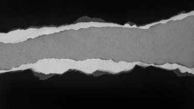 Gri arka planda yırtılmış siyah kağıt. Boşluğu kopyala