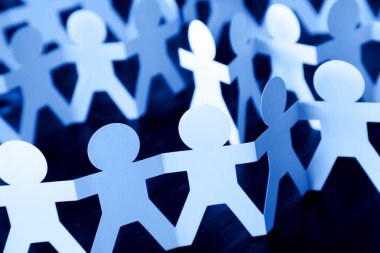 Kağıt zincire bağlı insanlar el ele tutuşuyorlar.