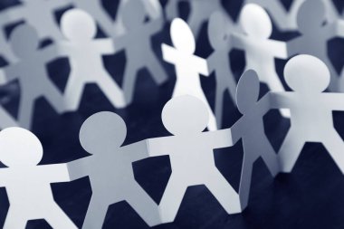 Kağıt zincire bağlı insanlar el ele tutuşuyorlar.