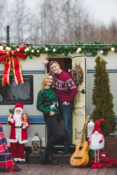 Joven Pareja Caucásica Alojándose Puerta Caravana Con Decoraciones Navidad Imagen de archivo