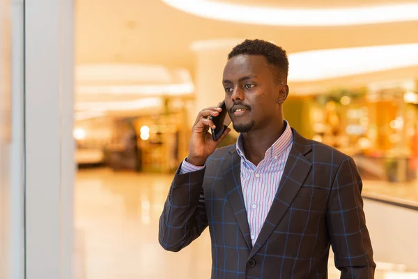 stock image Portrait of handsome African businessman using mobile phone