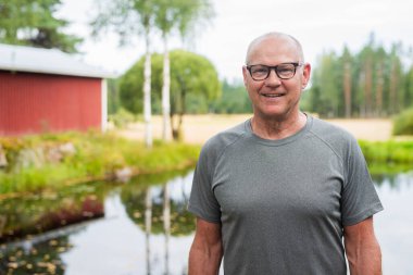 Senior Finnish Man Outdoors in a Scandinavian Forest Summer Portrait in the Woods clipart