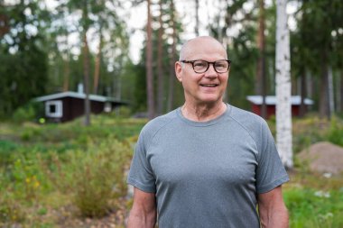 Senior Finnish Man Outdoors in a Scandinavian Forest Summer Portrait in the Woods clipart