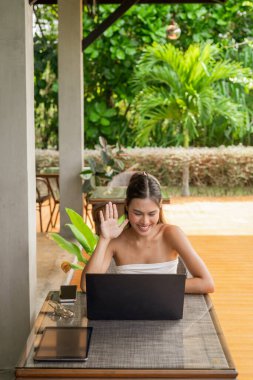 Young woman working on laptop in the restaurant concept clipart