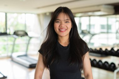 Genç ve güzel Asyalı kadın spor salonunda egzersiz yapıyor.