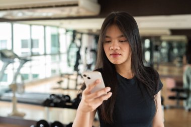 Genç ve güzel Asyalı kadın spor salonunda egzersiz yapıyor.