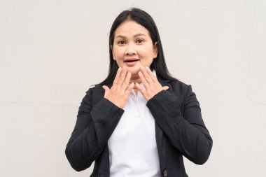 Beyaz arka planda iş kıyafetleri giymiş olgun Asyalı kadın portresi