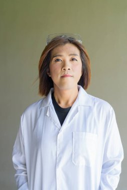 Kendine güvenen transseksüel STEM meslek laboratuvar önlüğü ve koruyucu gözlük takan ikili olmayan kişi