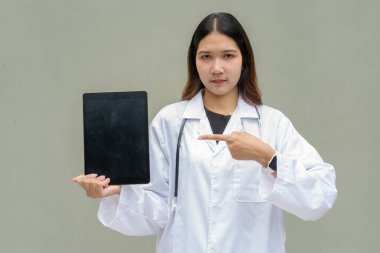 Beyaz laboratuvar önlüğü ve steteskop giyen genç Asyalı kadın doktor.