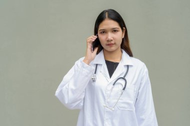 Beyaz laboratuvar önlüğü ve steteskop giyen genç Asyalı kadın doktor.