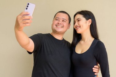 Duvarda asılı duran Asyalı genç bir çiftin portresi