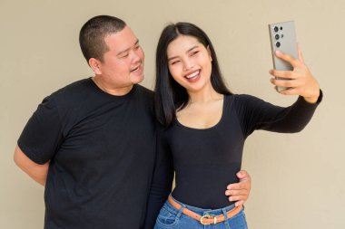 Duvarda asılı duran Asyalı genç bir çiftin portresi