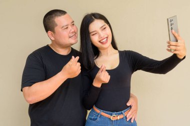 Duvarda asılı duran Asyalı genç bir çiftin portresi