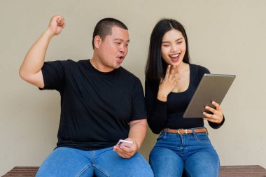 Duvarda asılı duran Asyalı genç bir çiftin portresi