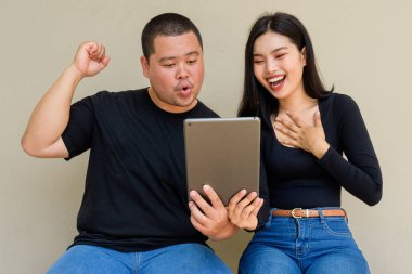 Duvarda asılı duran Asyalı genç bir çiftin portresi