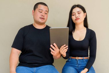 Duvarda asılı duran Asyalı genç bir çiftin portresi