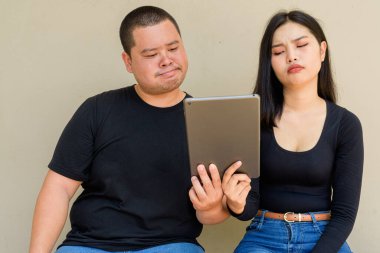 Duvarda asılı duran Asyalı genç bir çiftin portresi