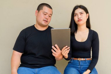 Duvarda asılı duran Asyalı genç bir çiftin portresi