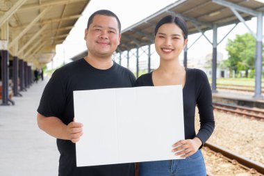 Genç Asyalı çift tren istasyonunda beraberler.