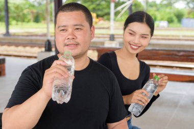 Genç Asyalı çift tren istasyonunda beraberler.