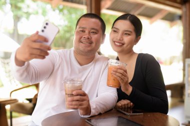Kafede oturan mutlu genç Asyalı çift