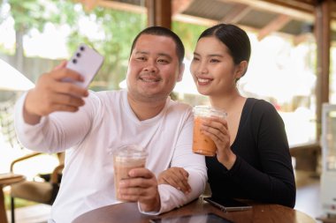 Kafede oturan mutlu genç Asyalı çift