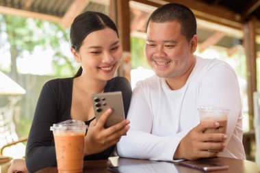 Kafede oturan mutlu genç Asyalı çift