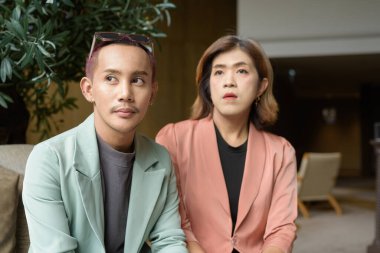 Asyalı transseksüel kadın ve kafede uzaktan çalışan ikili olmayan iş arkadaşları.