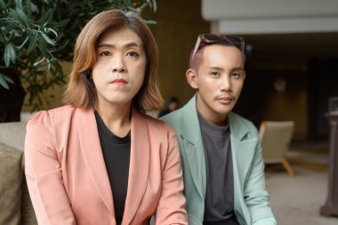 Asyalı transseksüel kadın ve kafede uzaktan çalışan ikili olmayan iş arkadaşları.