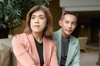 Asyalı transseksüel kadın ve kafede uzaktan çalışan ikili olmayan iş arkadaşları.