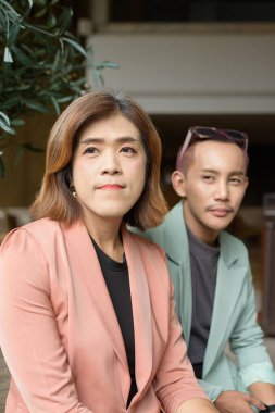 Asyalı transseksüel kadın ve kafede uzaktan çalışan ikili olmayan iş arkadaşları.