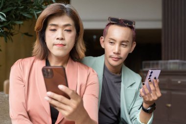 Asyalı transseksüel kadın ve kafede uzaktan çalışan ikili olmayan iş arkadaşları.