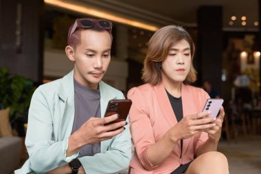 Asyalı transseksüel kadın ve kafede uzaktan çalışan ikili olmayan iş arkadaşları.