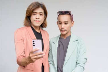 Transseksüel ve ikili olmayan Asyalı iş arkadaşları sade arkaplana karşı