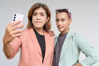 Transseksüel ve ikili olmayan Asyalı iş arkadaşları sade arkaplana karşı