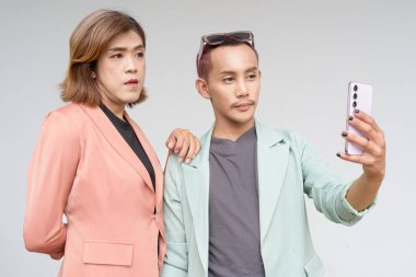 Transseksüel ve ikili olmayan Asyalı iş arkadaşları sade arkaplana karşı