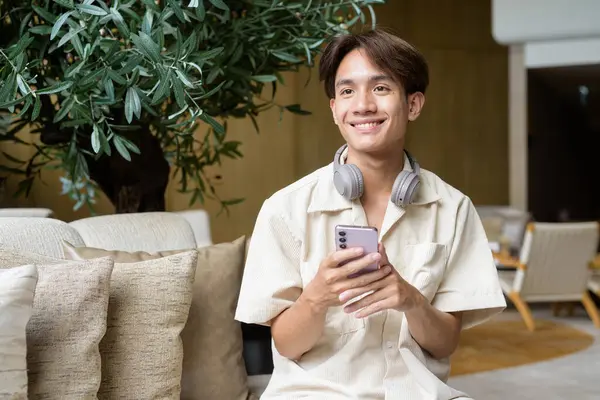 Modern kahve dükkanında oturan Asyalı yakışıklı olmayan çift yönlü öğrenci.