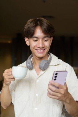 Modern kahve dükkanında oturan Asyalı yakışıklı olmayan çift yönlü öğrenci.