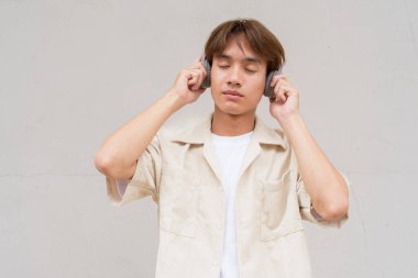 İkili olmayan sevimli Asyalı genç eşcinsel portresi düz arkaplanda