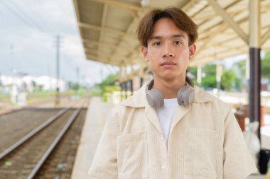 Tren istasyonunda iki kişilik olmayan genç Asyalı turist.