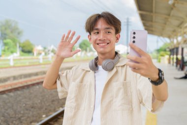 Tren istasyonunda iki kişilik olmayan genç Asyalı turist.